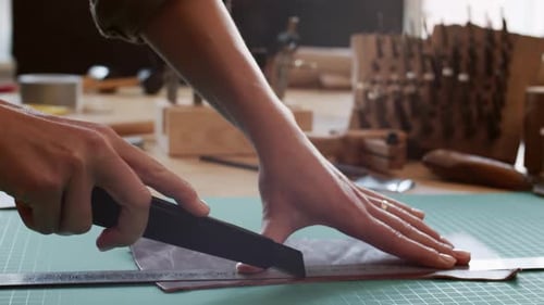 Leather Worker Cuts Material in Bright Studio