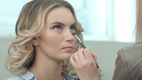 Woman Getting Makeup Applied by Makeup Artist