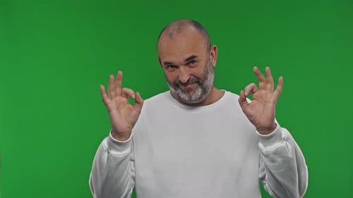 Happy Aged Man Showing Ok Sign Confirmation Gesture Approval Symbol Success on Isolated Green