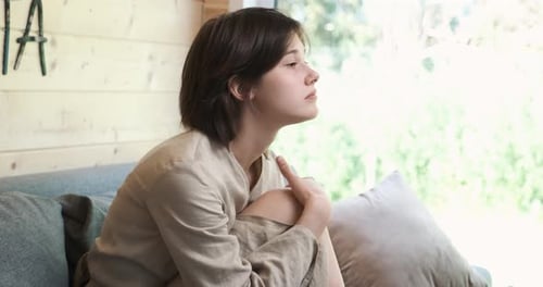 Pensive Woman Contemplates on Couch Indoors