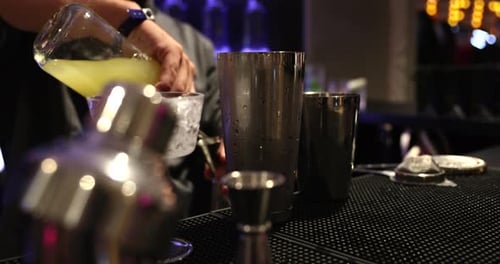 Bartender Prepares Refreshing Cocktail in Dark Bar
