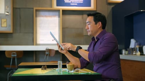 Man using digital tablet in cafe 4k