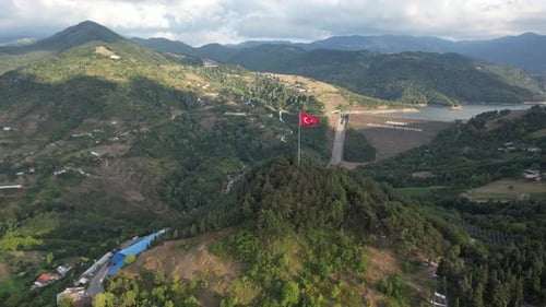 Mountainous Landscape with Lake and Waving Flag