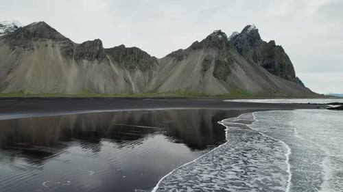 Drone Over Wet Black Sand Beach With Vestrahorn Mountain