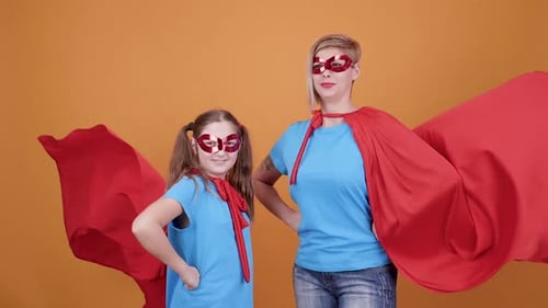 Woman and Girl in Superhero Costumes Posing