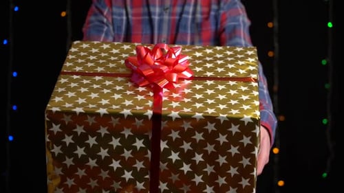 Man Offers Holiday Gift with Red Bow