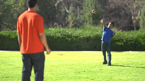 Father and Son Playing Football in the Park