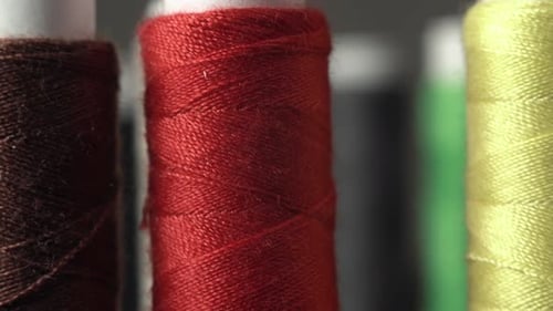 Sewing Threads On Spool. Extreme Closeup. Colorful Spools of Thread in Textile Factory. A Lot of
