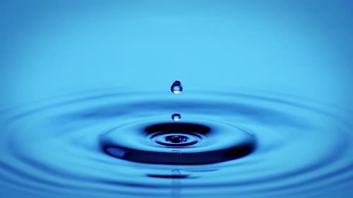 Water Drops Rippling on a Blue Surface
