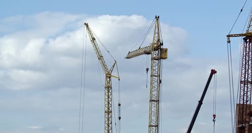 Los constructores construyen una casa de ladrillo. Las grúas gigantes están funcionando