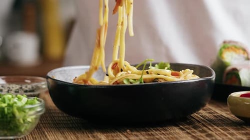 Noodles in Bowl Lifted with Chopsticks