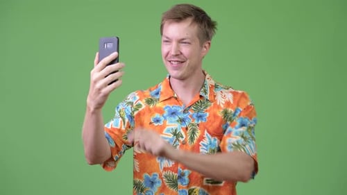 Junger glücklicher gutaussehender Tourist mit Telefon