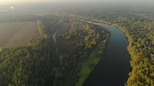 Amazing and Fabulous Landscape of Winding River and Forest at Dawn in the Fog