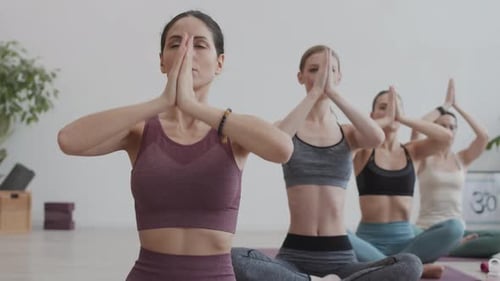 Women Practicing Yoga in Bright Studio