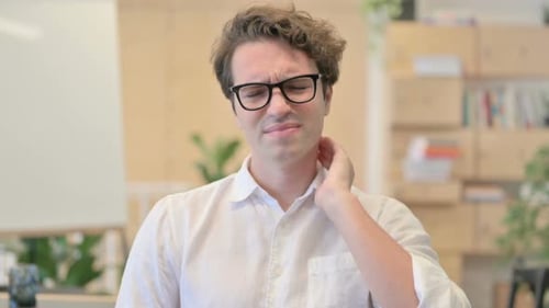 Man Massaging Stiff Neck in Office Environment