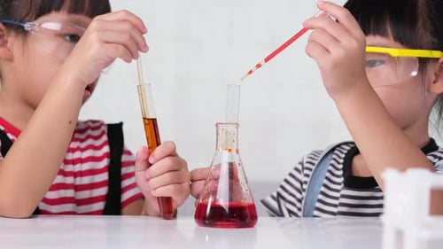 Two Young Girls Conduct Science Experiment in Lab