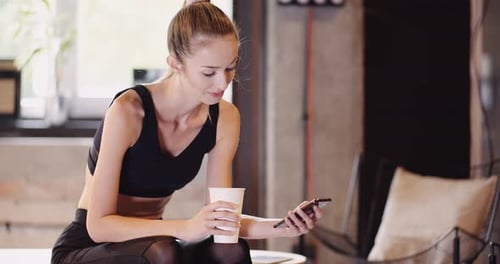 Athletic Woman Using Smartphone At Health Club