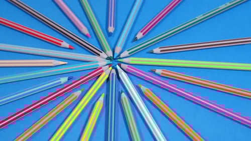 Starburst of Striped Colored Pencils on Blue Surface
