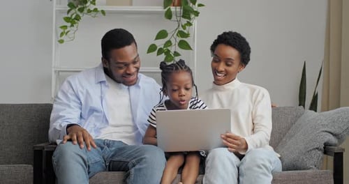 Family Using Laptop Together on Couch at Home