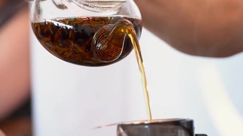 Pouring Tea from Glass Pot into Strainer