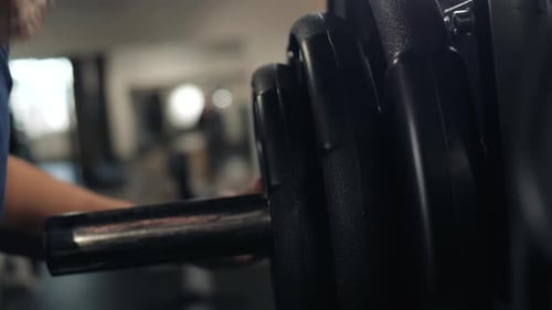 Close Up of Handsome Bodybuilder Guy Prepare to Do Exercises with Barbell in a Gym Keep Barbell