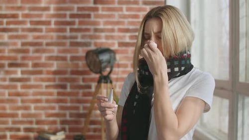 Woman with Cold Wipes Nose and Checks Temperature