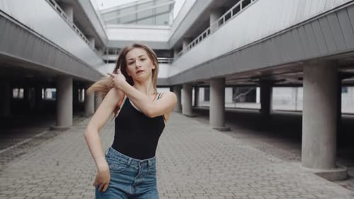 Expressive Young Woman Dancing in Urban Setting