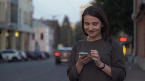 Happy Girl Using a Smart Phone Voice Recognition Audio Message Function on Line Walking on a Street