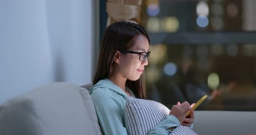 Woman wear glasses and use of mobile phone at home