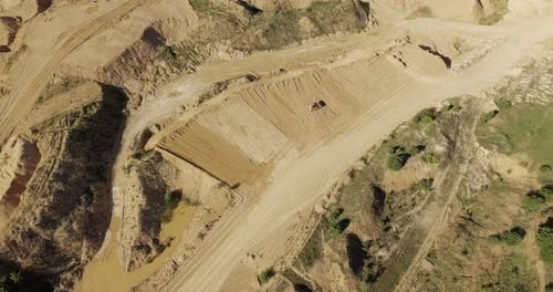 Aerial View of Tractor Digging in Sandy Landscape
