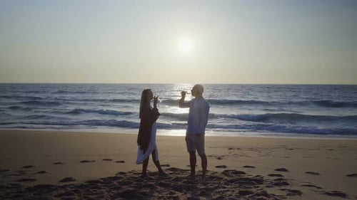 Couple Drinking Wine on Beach at Sunset