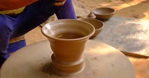Des mains habiles de potier façonnent l'argile sur Potter Wheel et sculptent un pot en argile. Shipagramme