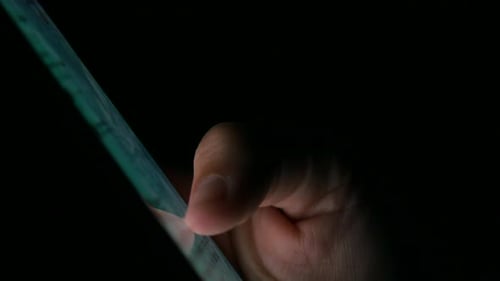 Hand Uses Touch Screen Device in the Dark