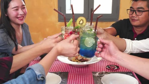 Friends Toasting Drinks Together at Restaurant Table
