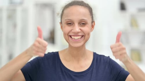 Porträt einer positiven Afrikanerin mit Daumen hoch
