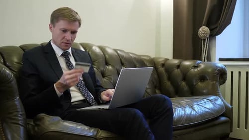 Adult Using Laptop and Credit Card Indoors