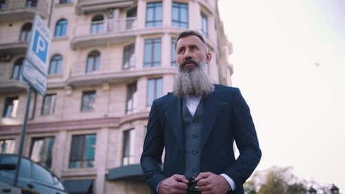 Portrait of Handsome Bearded Mature Man in Suit Outdoors on Modern Building Background During Sunny