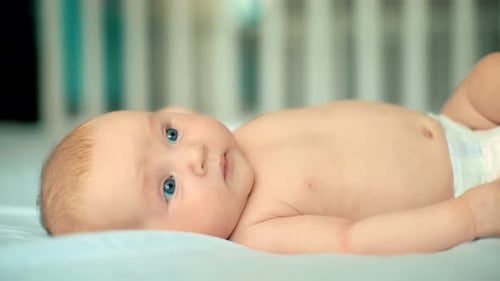 Infant Lying on Back in Crib Looking Up