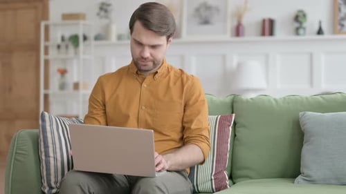 Man Using Laptop Then Leaving Sofa in Home