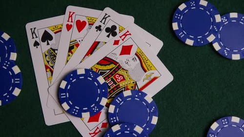 Rotating shot of poker cards and poker chips on a green felt surface - POKER 012