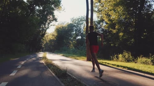 Sporty Man Jogging on Road in Slow Motion