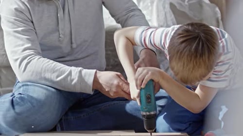 Father and Son Building Furniture Together Indoors