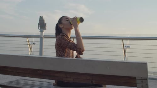 Woman Enjoys City View with Reusable Cup