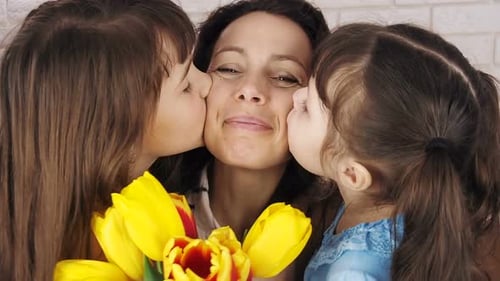 Loving Mother Receives Kisses from Daughters