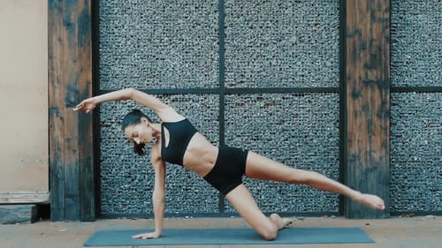 Woman Doing Yoga Side Plank Exercise Outdoors