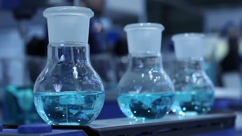 Close Up of Glass Beakers with Turquoise Fluid