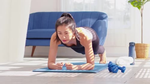 Woman Doing a Plank Exercise on Yoga Mat