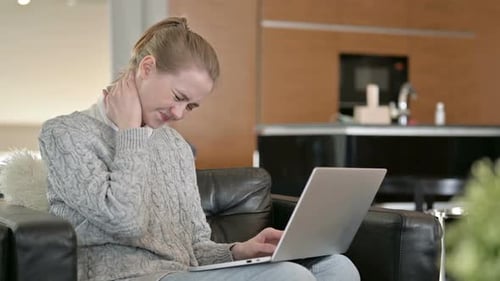 Young Woman With Neck Pain Using Laptop