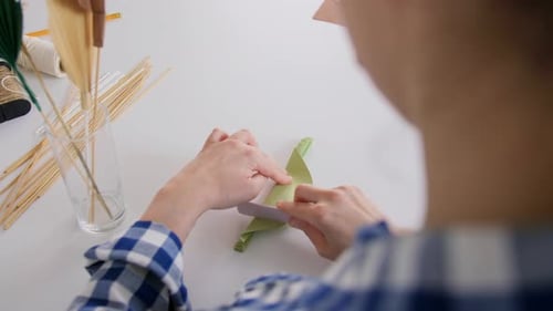 Woman Crafting Paper Leaf at White Table