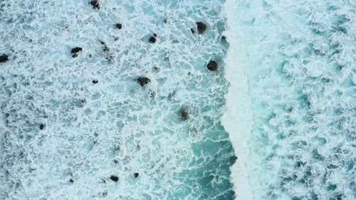 Aerial View of Ocean Waves Crashing on Shore